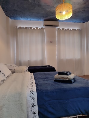 A bedroom with a bed, a bedside table, a lamp, and a ceiling fan. - Little Africa Loft (Rio de Janeiro)