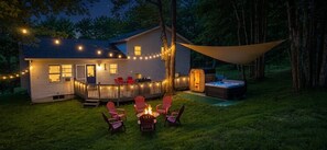 A house with a deck, outdoor seating, a hot tub, and string lights. - Pocono Retreat ! Hot Tub + Sauna ! Sleeps 8 (Long Pond)