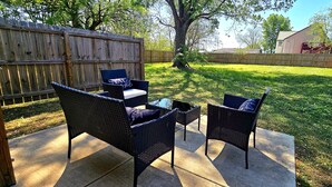 An outdoor patio with wicker furniture and a small table. - Modern 2BR/2BA Home. Large Backyard. 5 Gig Fiber. Nr VBC, Arsenal & Space Center (Huntsville)