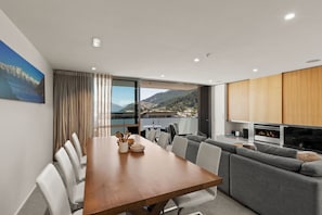 Ein modernes Wohnzimmer mit Essbereich, großen Fenstern und Bergblick sowie einer gemütlichen Sitzecke.