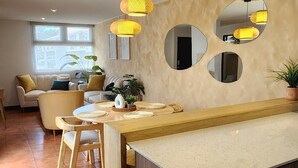 Una cocina moderna con una isla central, armarios de madera y un comedor con sofá y sillas.