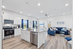 Een moderne keuken met witte kasten, roestvrijstalen apparatuur en een centraal eiland.