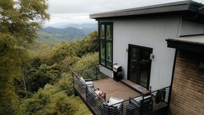 A modern house with a balcony overlooking a forested valley. - Private Luxe Mountain View Getaway (Candler)