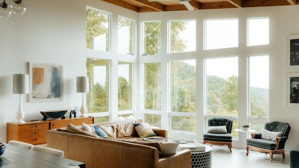 A spacious living room with a large window, a brown sofa, two armchairs, a wooden coffee table, and a small side table. - Private Luxe Mountain View Getaway (Candler)