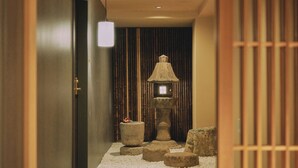 En korridor med en traditionell japansk lykta, stentrappor och en hängande lampa.