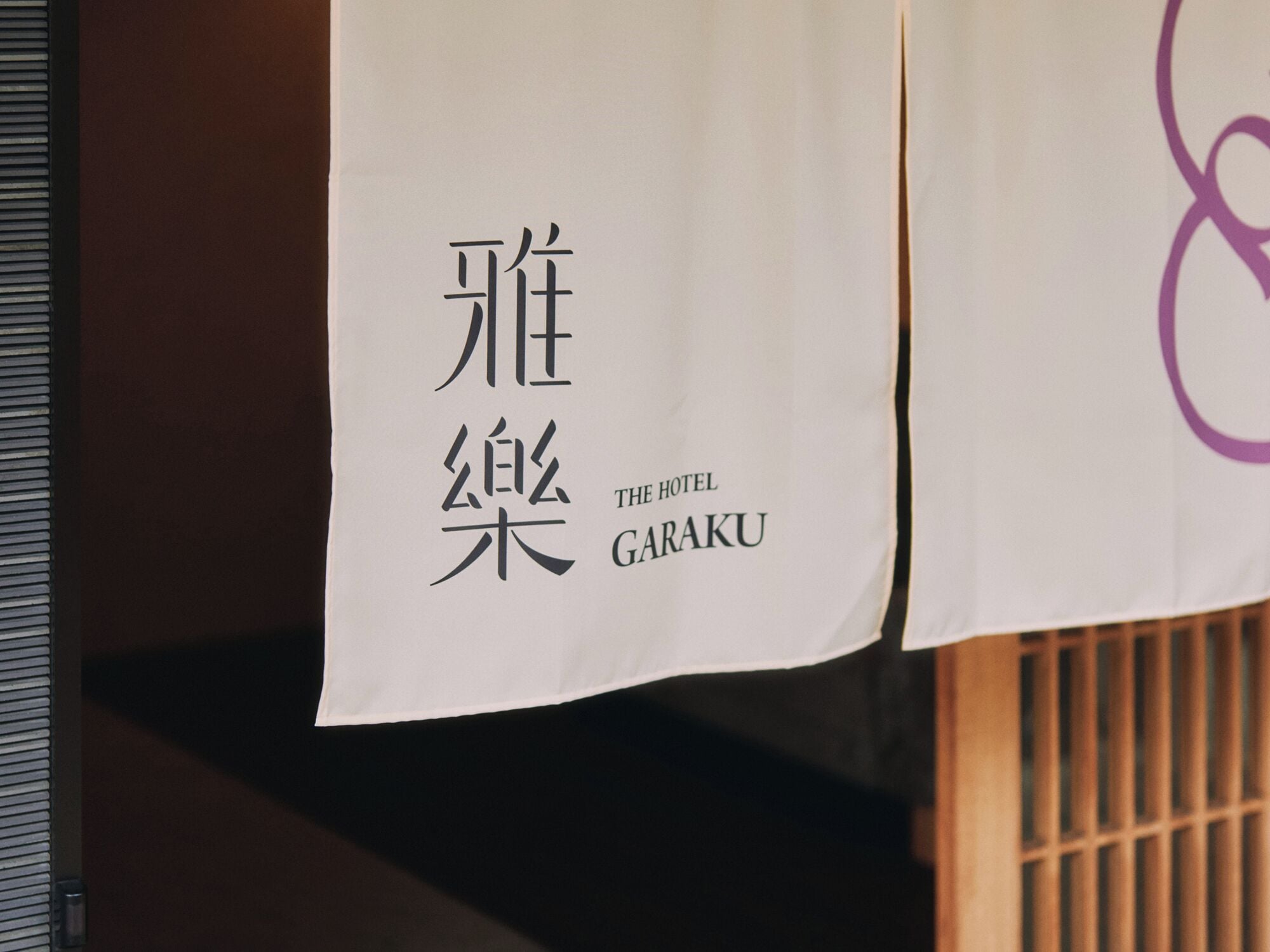 Un letrero de hotel con caracteres japoneses y el nombre 'THE HOTEL GARAKU'.