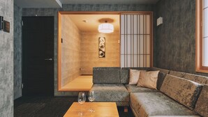 En modern inredning med en soffa, ett soffbord i trä och en traditionell japansk skjutdörr.