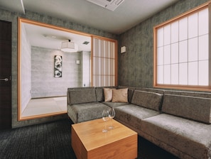 Una sala moderna con sofá, mesa de centro y un amplio ventanal.