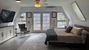 A bedroom with a bed, a desk, a chair, and a ceiling fan. - Deland Dome Home- 98" TV - Open Kitchen (DeLand)