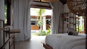 Une chambre avec un grand lit, des meubles en bois et une vue sur un jardin.