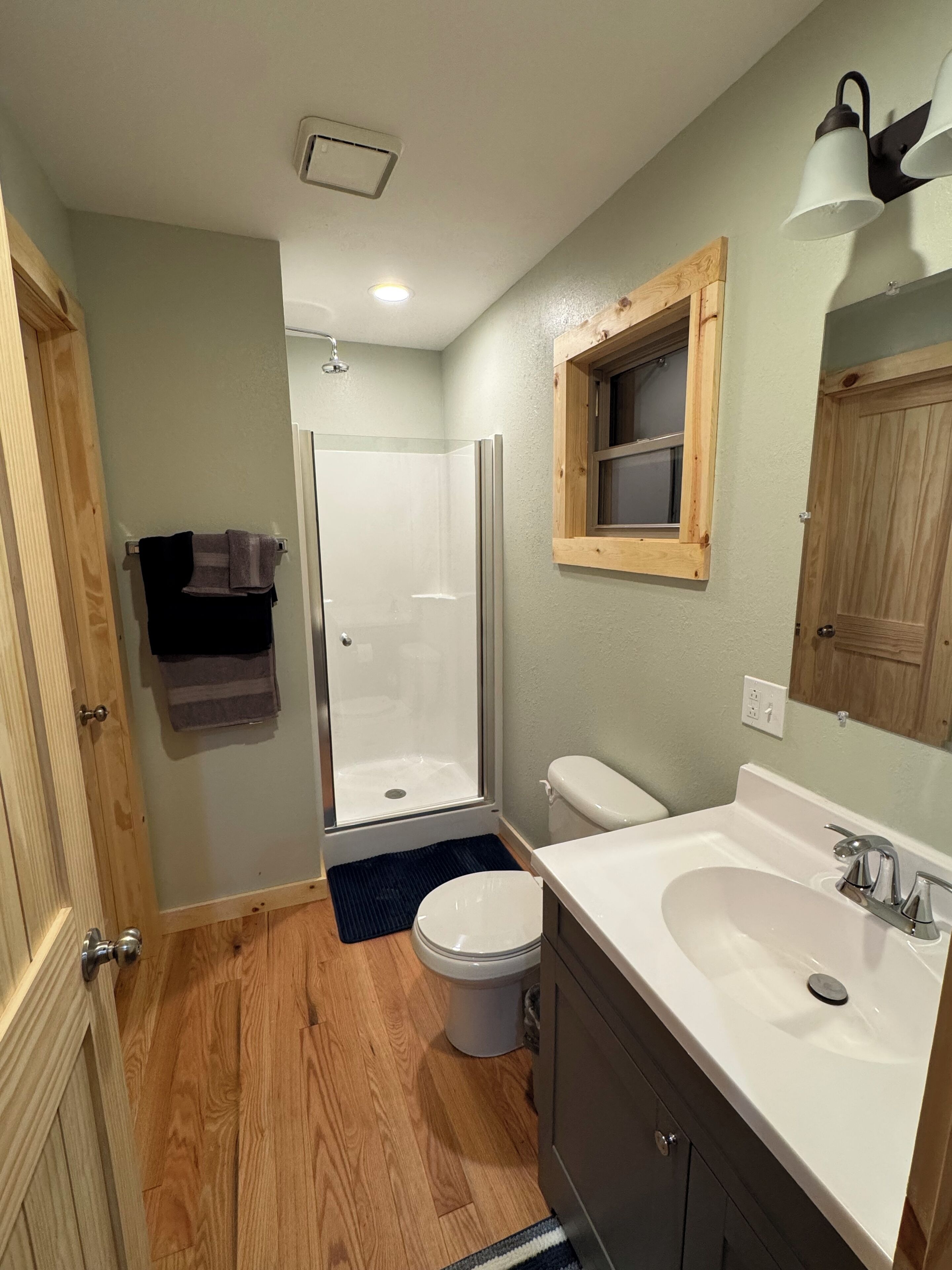 A bathroom with a shower, toilet, and sink.
