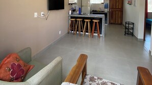 A living room with a sofa, a television, and a ceiling fan. - A very cozy house for couples! (Cabo Frio)