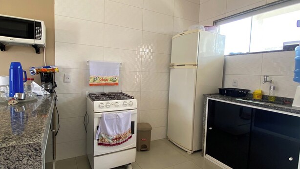 A kitchen with a microwave, stove, refrigerator, and granite countertop. - A very cozy house for couples! (Cabo Frio)
