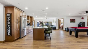 Eine moderne Küche mit Holzschränken, einem Edelstahlkühlschrank und einem freundlichen Willkommensschild.