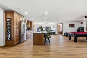 A modern kitchen with wooden cabinets, a stainless steel refrigerator, and a welcome sign. - Diamond Desert Resort , Game room , 4 BR:3 Baths (Scottsdale)