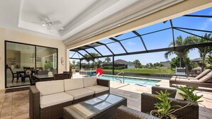 Ein Außenbereich mit Terrasse, Pool, Korbmöbeln und einer Glaskuppel.