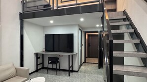 Ein modernes Interieur mit Schlafzimmer-Loft, Essbereich und Treppe.