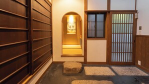 A traditional Japanese interior with a wooden sliding door, a small stone lantern, and a shoji screen door. - Quiet Gion Machiya:Private Tea Room&Matcha Experience.Illuminated Courtyard Bath (京都市)