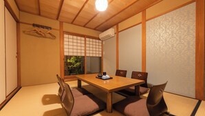 A traditional Japanese room with tatami flooring, a wooden table, and a shoji screen. - Quiet Gion Machiya:Private Tea Room&Matcha Experience.Illuminated Courtyard Bath (京都市)