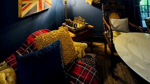 A room with a dark blue wall, a painting, a Union Jack flag, and mounted animal heads. - Downtown gem B&B, 2 ml from Buffalo Trace on Bourbon Trail (Frankfort)