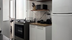 A modern kitchen with white cabinetry, a built-in oven, a coffee maker, and a toaster.