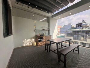 Deluxe-Vierbettzimmer, Balkon, Stadtblick | Speisen im Freien