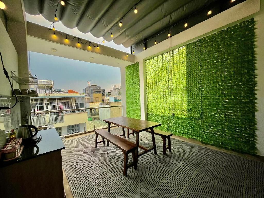 Une terrasse sur le toit agrémentée d’un mur végétal, d’une table en bois et d’un banc.