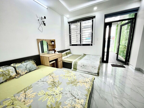 Une chambre à coucher comprenant un lit, un bureau, une chaise, un miroir et une fenêtre avec des stores.