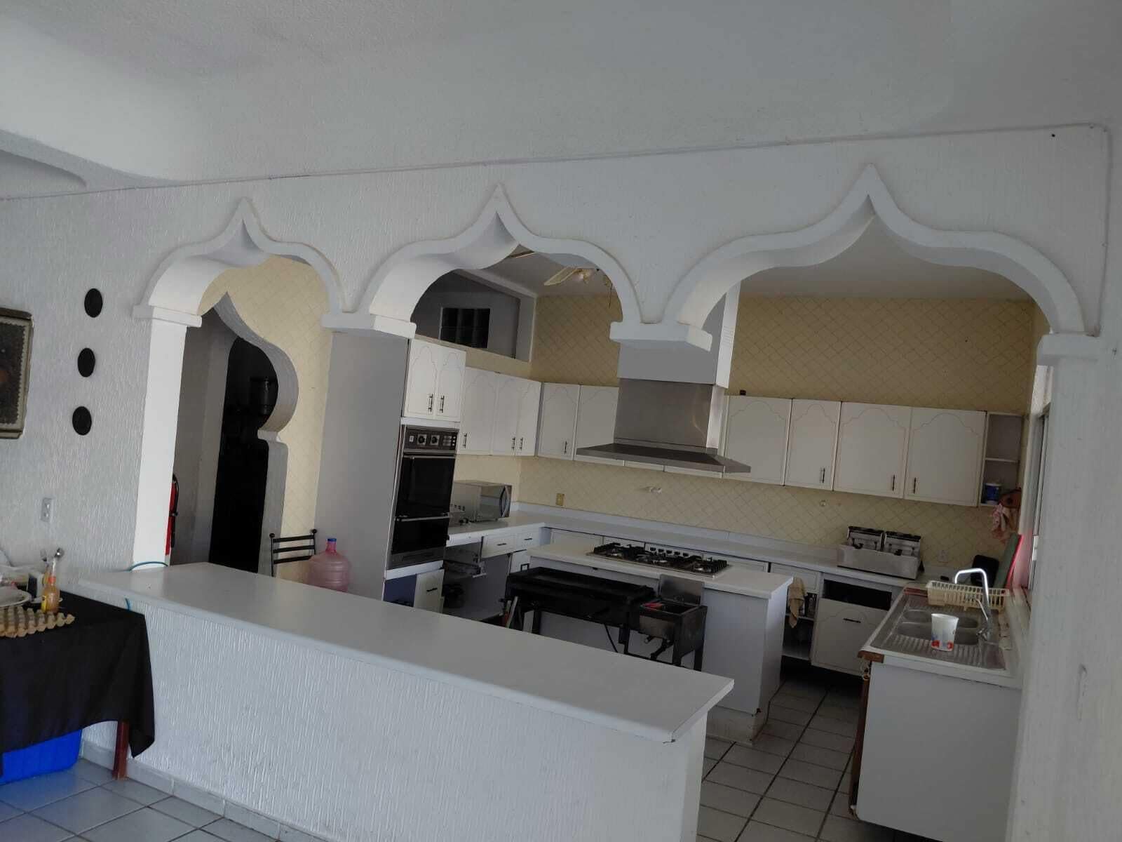 A kitchen with white cabinets, a central island, and a built-in oven.
