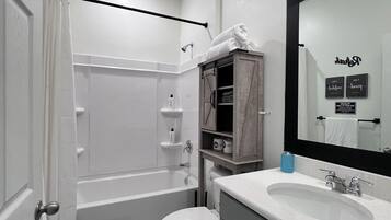 Een haardroger, handdoeken, zeep, toiletpapier