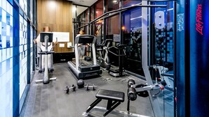 Ein modernes Fitnessstudio mit Laufbändern, Krafttrainingsgeräten und Kurzhanteln.