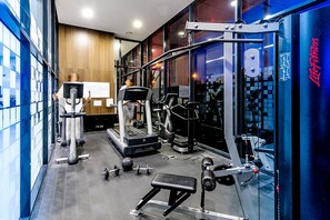Ein modernes Fitnessstudio mit Laufbändern, Krafttrainingsgeräten und Kurzhanteln.