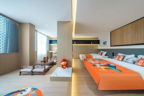 A modern hotel room with a sofa bed, a small table, and a decorative toy.