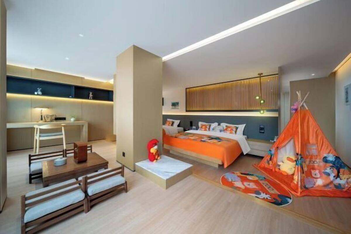 Ein modernes Hotelzimmer mit Bett, Schreibtisch und Sitzecke.