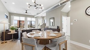 Un comedor moderno con una mesa redonda dispuesta para seis personas, rodeada de seis sillas.