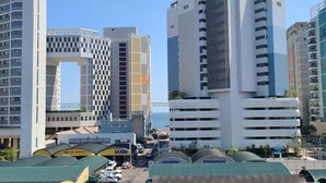 Un quartier urbain moderne, caractérisé par de nombreux immeubles de grande hauteur, dont un bâtiment remarquable avec une grande structure en forme d’arc.