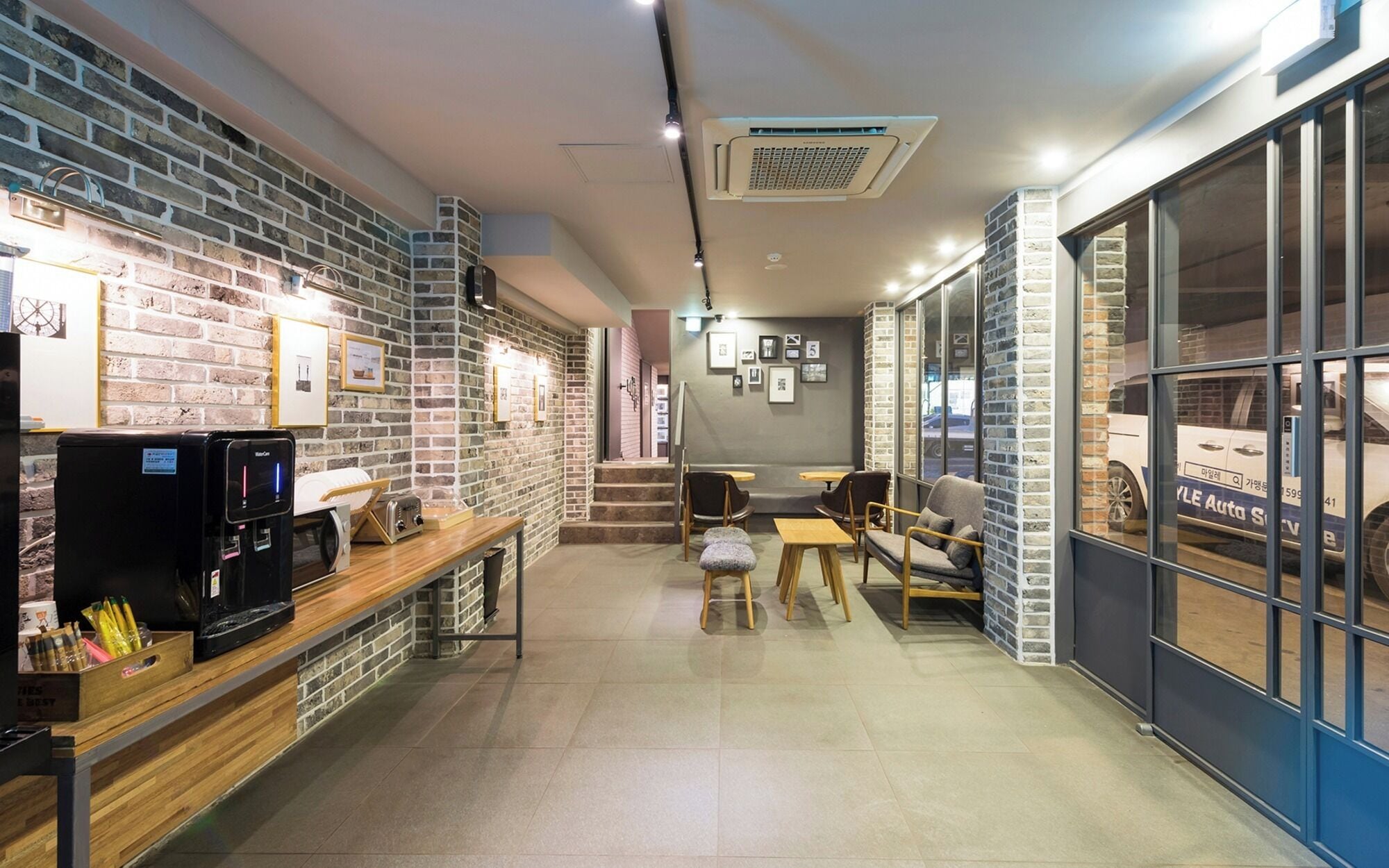 A modern interior with a brick wall, a coffee machine, and seating area.