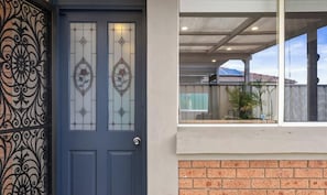 A blue door with decorative glass panels and a wrought iron gate.