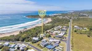An aerial view of a coastal residential area with houses, a road, and a beach. - Hidden Gem, Sauna, Pet-Friendly! (Arrawarra Headland)