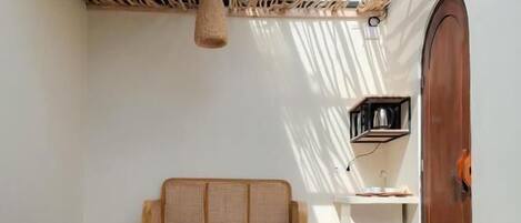 A spa area with a hot tub, wooden bench, and a small shelf with a cup.