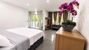 A bedroom with a bed, a wooden dresser, a plant, and a view of the outdoors. - Spacious 5-bedroom house in lovely Costa del Sol Front Beach (Costa del sol)