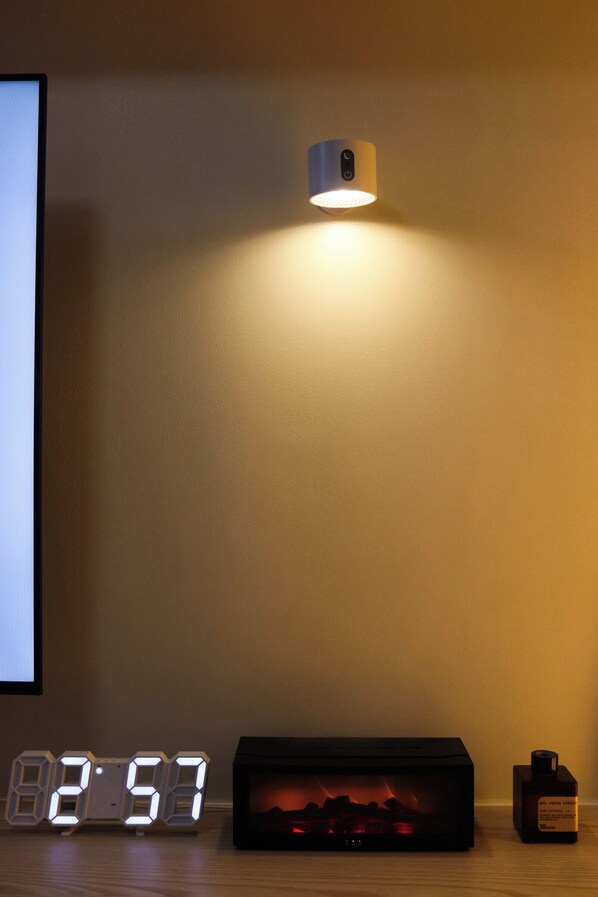 A digital clock displaying 8:57, a small heater, and a wall-mounted light fixture.