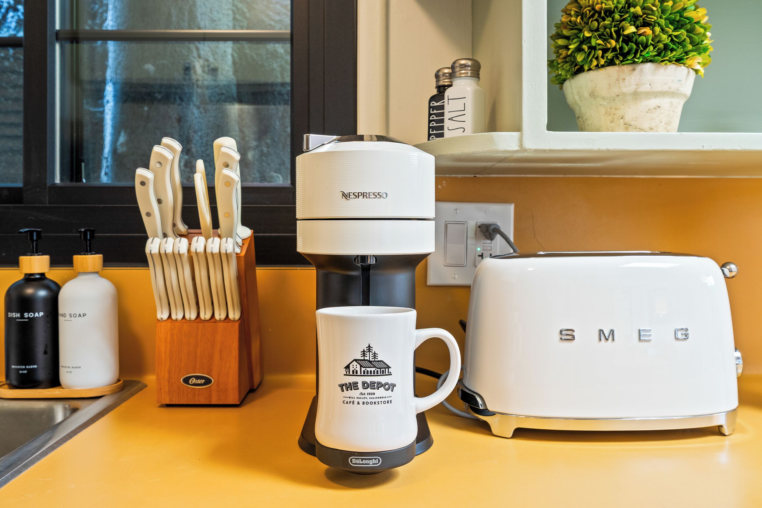 A kitchen counter with a coffee maker, a toaster, and a mug.