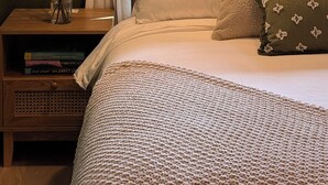 A bedroom with a bed, a nightstand, a lamp, a window with curtains, and a view of trees. - Serene Mill Valley Retreat - King Bed, Walk to Downtown, Deck, Sleeps 4. (Mill Valley)