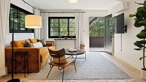 A modern living room with a sofa, chairs, a table, and a large window. - Serene Mill Valley Retreat - King Bed, Walk to Downtown, Deck, Sleeps 4. (Mill Valley)