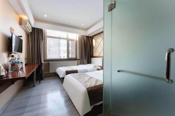 A hotel room with two beds, a desk with a television, and a window with curtains. - Jinma Hotel (Qiqihar)