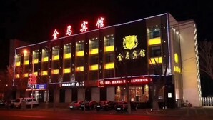 A building with illuminated signage and multiple windows, suggesting a commercial or public building. - Jinma Hotel (Qiqihar)