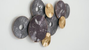Eine Ansammlung von metallischen Objekten in verschiedenen Farben und Texturen, angeordnet vor einem schlichten Hintergrund.