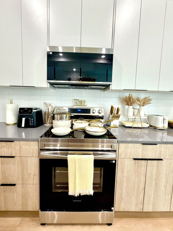 A modern kitchen with stainless steel appliances, a microwave, and a Samsung oven.