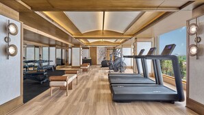 A gym with treadmills, exercise bikes, and weight machines. - Slohh by Roach Bengaluru, Curio Collection by Hilton (Bengaluru)